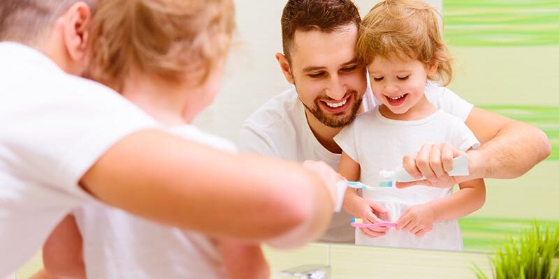 Familienvater und Tochter putzen Zähne zusammen im Bedezimmer Familienvater und Tochter putzen Zähne zusammen im Bedezimmer