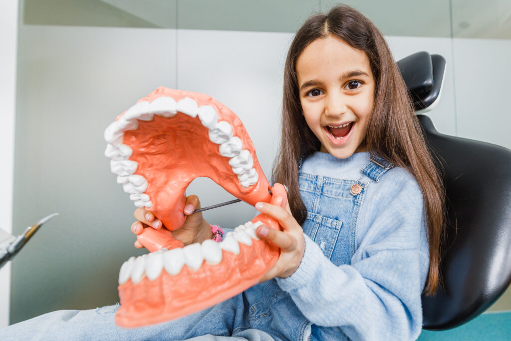 Junges Mädchen hält begeistert ein großes Modell eines Mundes